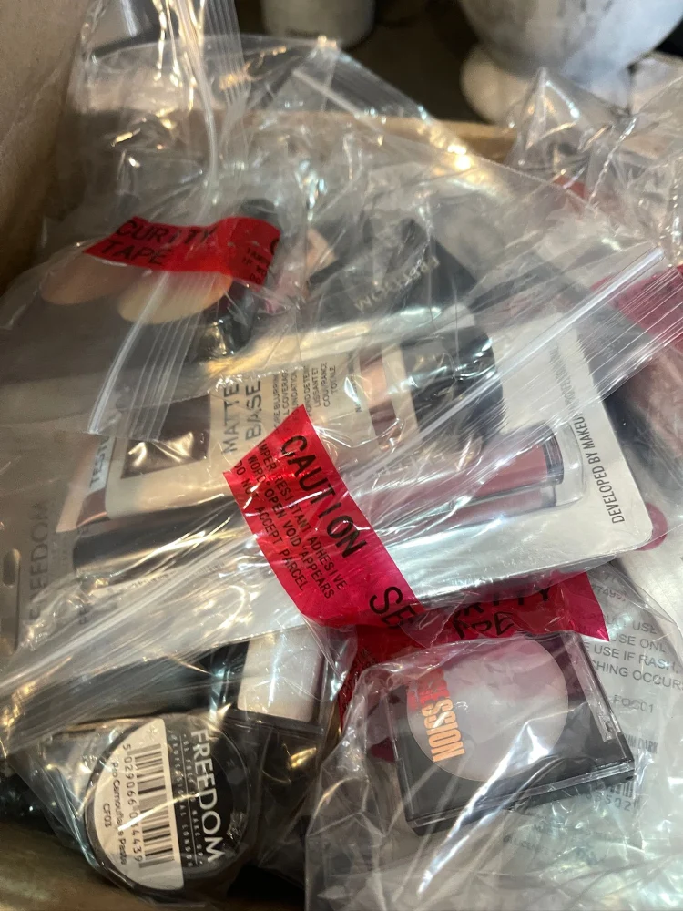 Security-sealed mystery clearance bundle containing branded high-street cosmetics and retail items including The Whit…