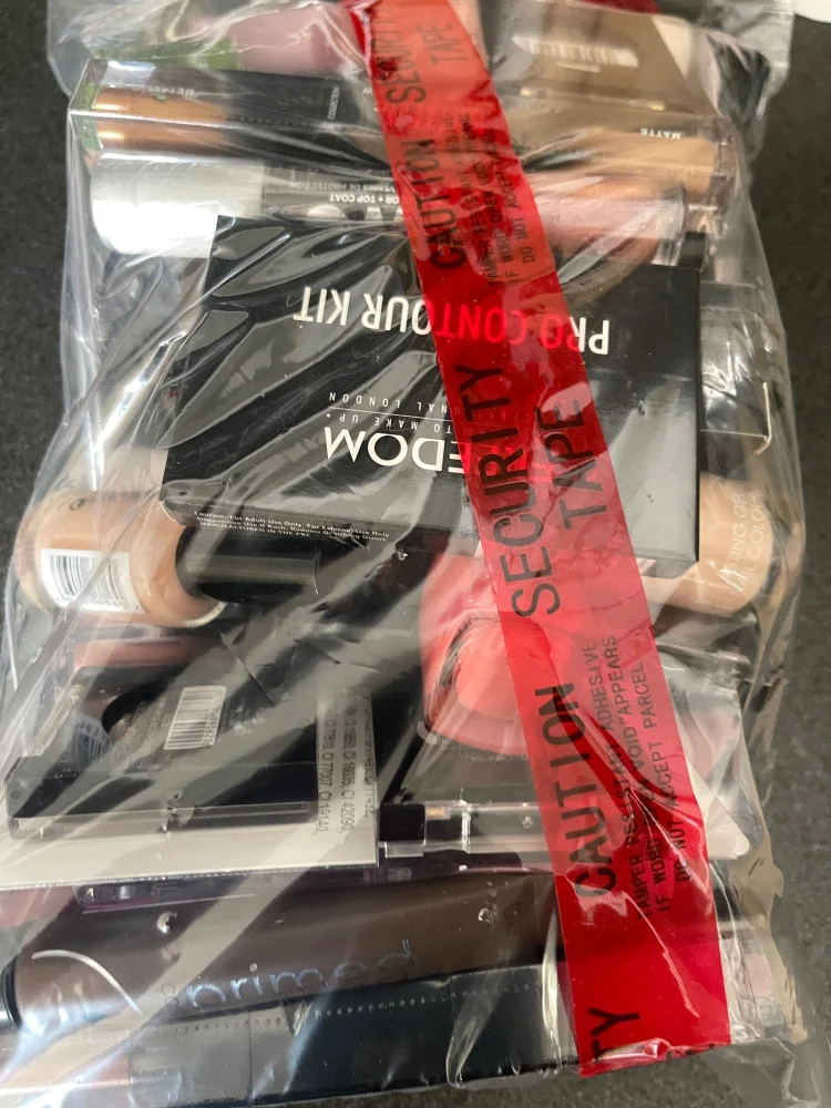 Security-sealed mystery clearance bundle containing branded high-street cosmetics and retail items including The Whit…